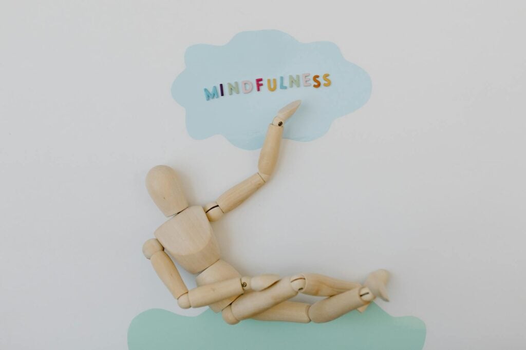 How Can I Manage Bipolar Disorder Mood Swings That Disrupt My Daily Life? 2 Wooden mannequin depicting mindfulness concept against pastel background.