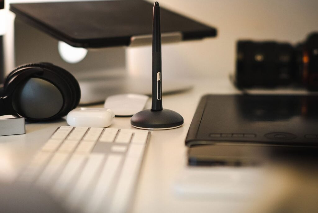How Can I Manage ADHD-Related Time Blindness to Improve Everyday Productivity? 2 A sleek modern workspace featuring a graphic tablet, stylus, keyboard, headphones, and camera.